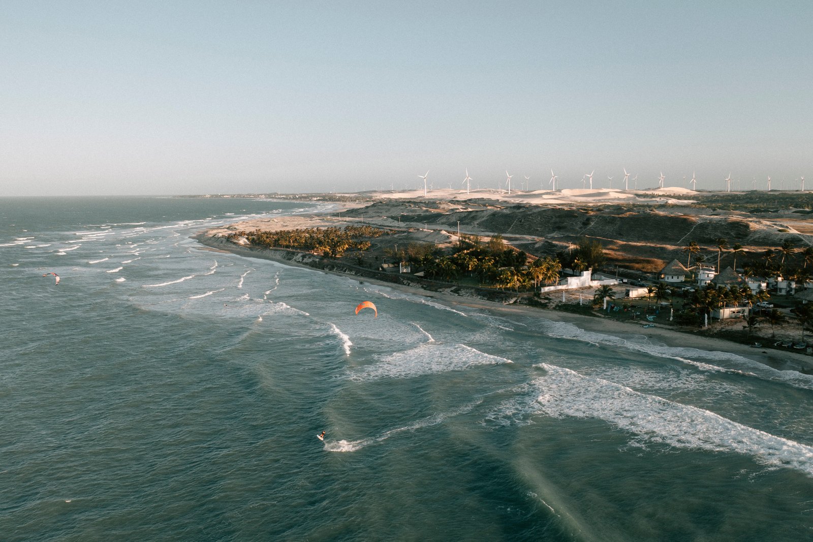 Aerial view of Emboaca bay with kitesurfers riding flat water along the Ceará coast