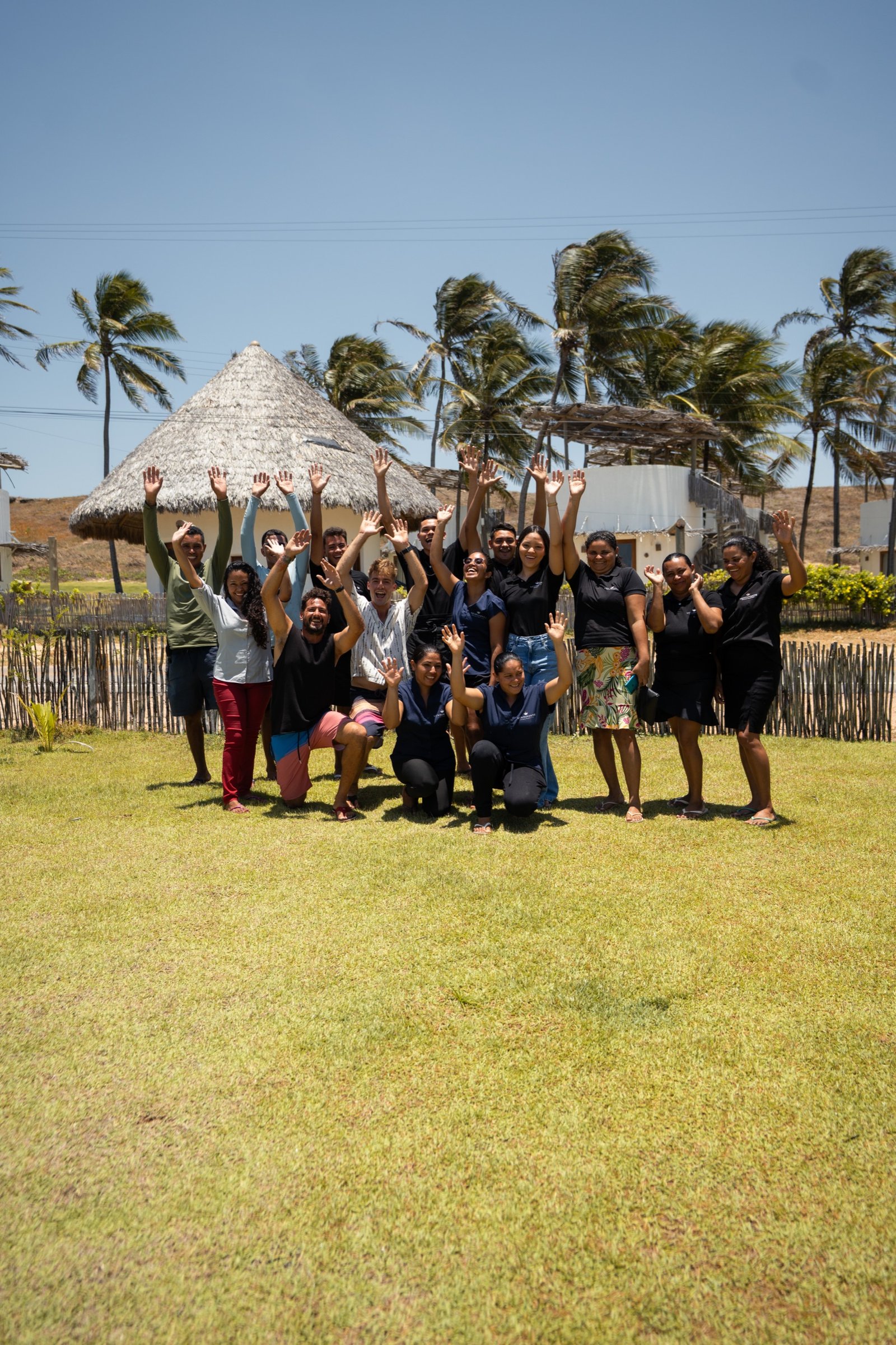 The VentoVinte team gathered on the lawn in front of the round bungalows