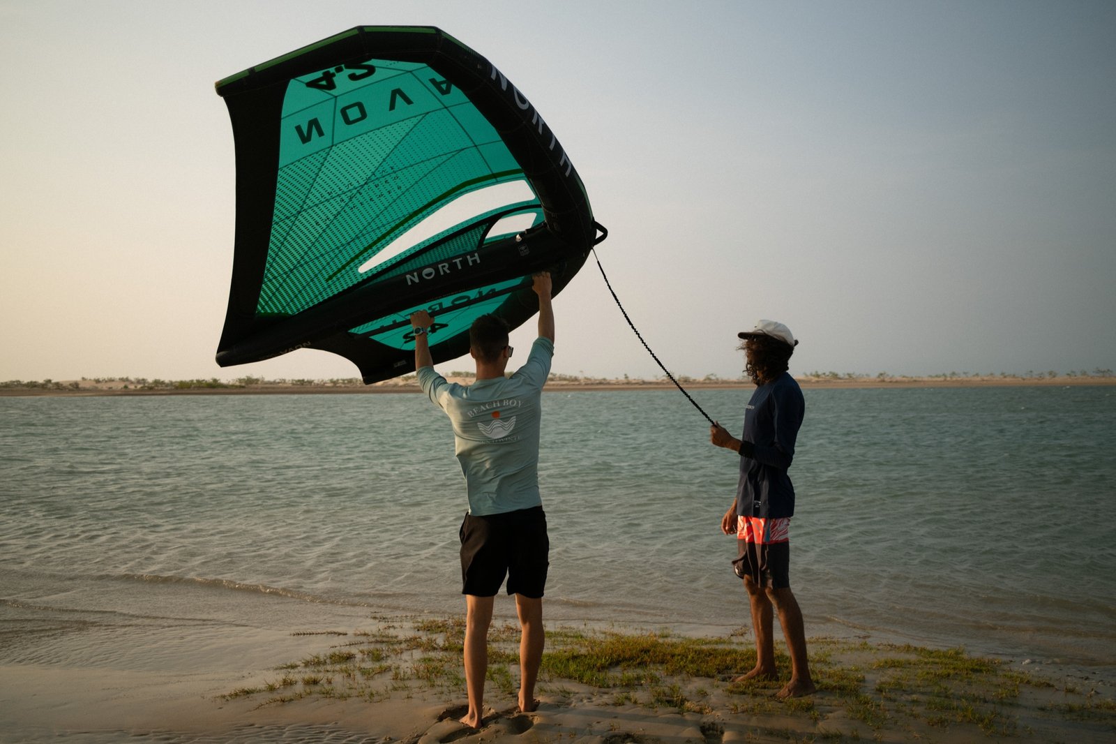 Student walking out to the foilboard on the flat lagoon for first flights
